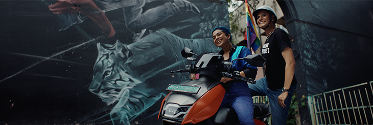  Riders Riding VIDA Electric Scooter with flag in Hand